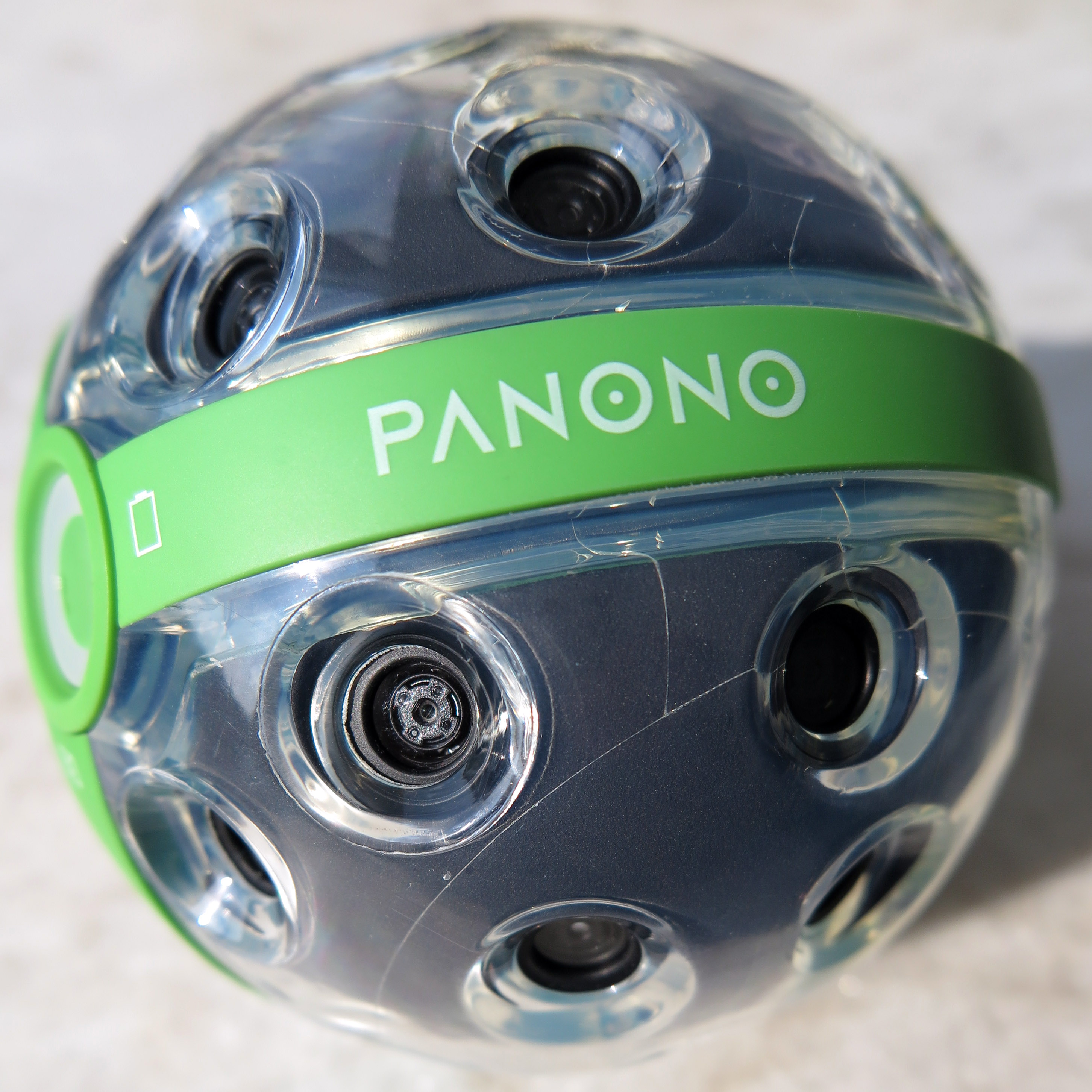 Panono spherical camera with a green center band and multiple lenses