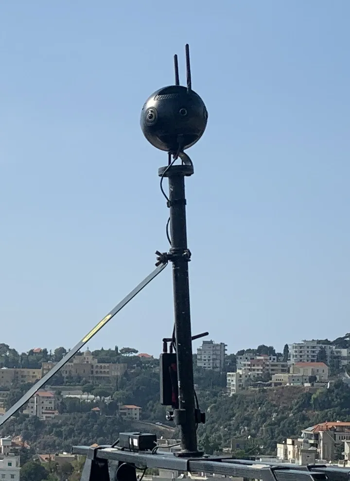 Insta360 Pro 2 camera mounted above a car during an outdoor 360 capture.
